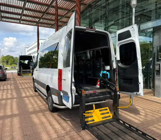 Professionele rolstoeltaxi chauffeur helpt klant in Aalsmeer